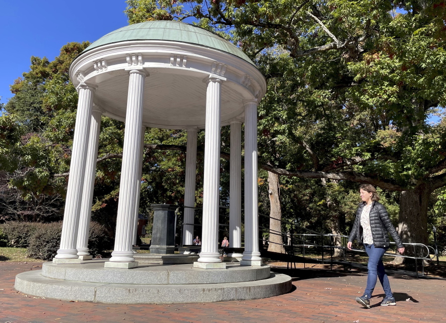 A student walks by the Old Well at the University of North Carolina Chapel Hill, a rotunda and campus landmark at the southern end of McCorkle Place, on Monday. A Confederate statue known as Silent Sam stood in the plaza before it was toppled by protesters in 2018.