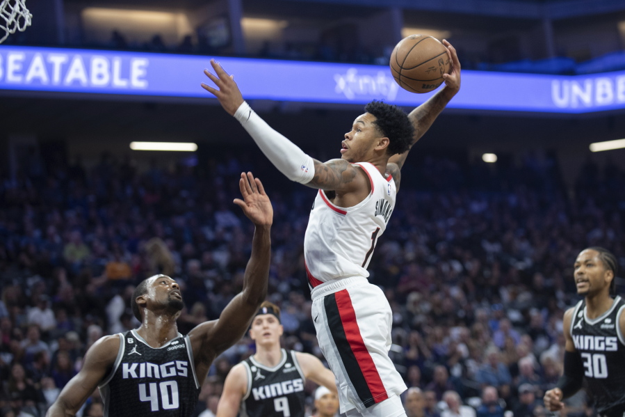 Portland Trail Blazers guard Anfernee Simons (1) goes up for a shot over Sacramento Kings forward Harrison Barnes (40) during the first quarter of an NBA basketball game in Sacramento, Calif., Wednesday, Oct. 19, 2022. (AP Photo/Jos?