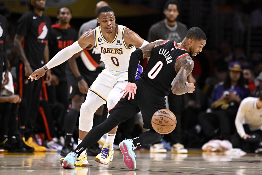 Portland Trail Blazers guard Damian Lillard, right, loses the ball with Los Angeles Lakers guard Russell Westbrook defending during the first half of an NBA basketball game Sunday, Oct. 23, 2022, in Los Angeles.