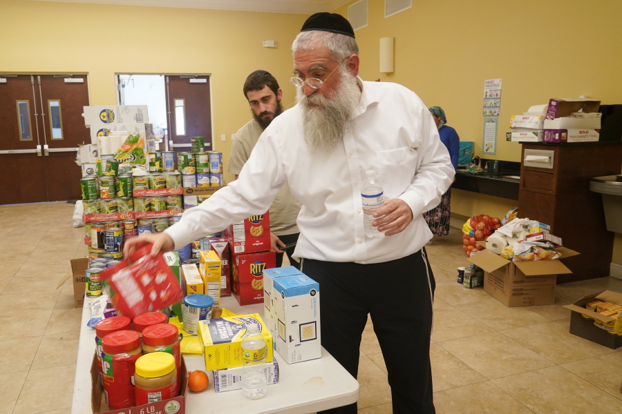 Rabbi Yitzchok Minkowicz supervises the pantry inside the Chabad Lubavitch of Southwest Florida, Monday, Oct. 3, 2022, in Fort Myers, Fla. The synagogue has been transformed into a full-fledged community center with food trucks and a pantry. They plan on celebrating Yom Kippur on Tuesday.