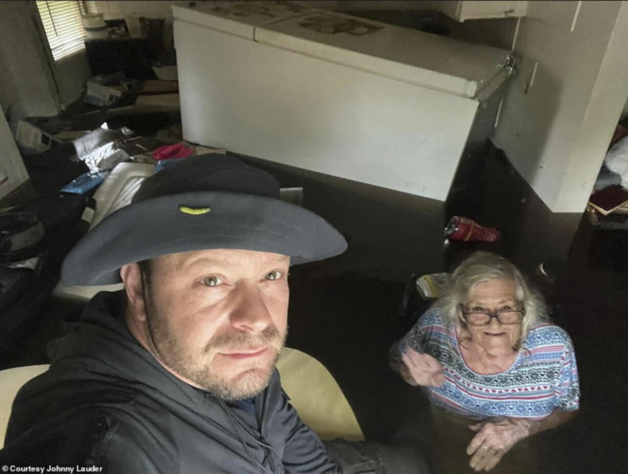In this photo provided by Johnny Lauder, Lauder takes a selfie with his mother, Karen Lauder, 86, as he came to rescue her after water flooded her home, in Naples, Fla., Wednesday, Sept. 28, 2022, following Hurricane Ian.