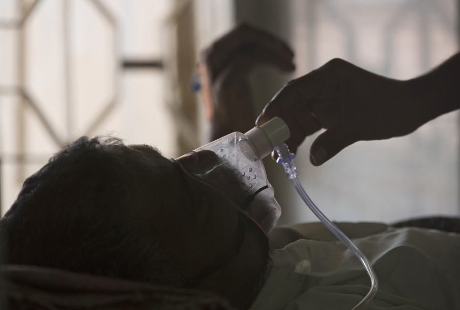 FILE - A relative adjusts the oxygen mask of a tuberculosis patient at a TB hospital on World Tuberculosis Day in Hyderabad, India, March 24, 2018. The number of people infected with tuberculosis, including the kind resistant to drugs, rose globally for the first time in years, according to a report issued Thursday, Oct. 27, 2022 by the World Health Organization.