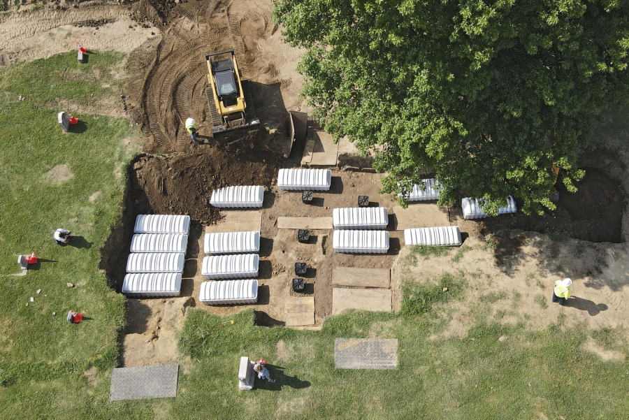 FILE - In this aerial photo, a mass grave is re-filled with dirt after a small ceremony at Oaklawn Cemetery on July 30, 2021, in Tulsa, Okla. The mass grave was discovered while searching for victims of the Tulsa Race Massacre. Some of the 19 bodies taken from the Tulsa cemetery that are possible victims of the 1921 Tulsa Race Massacre will be exhumed again starting Wednesday, Oct. 26, 2022, to gather more DNA for possible identification.