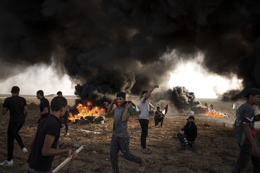FILE - Palestinians burn tires during a protest against Israeli military raid in the West Bank, along the border fence with Israel, in east of Gaza City on Oct. 25, 2022. The U.N. Mideast envoy said 2022 is on course to be the deadliest year for Palestinians in the West Bank since the U.N. started tracking fatalities in 2005, and he called for immediate action to calm "an explosive situation" and move toward renewing Israeli-Palestinian negotiations.