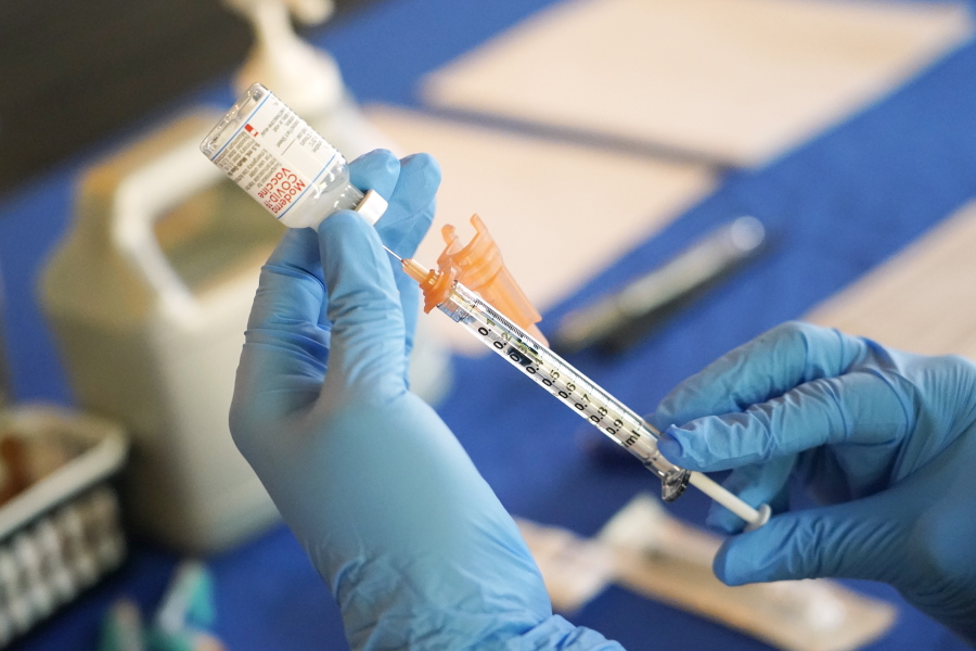 FILE - A nurse prepares a syringe of a COVID-19 vaccine at an inoculation station in Jackson, Miss., Tuesday, July 19, 2022. On Thursday, Oct. 20, 2022, a panel of U.S. vaccine experts said COVID-19 shots should be added to the lists of recommended vaccinations for kids and adults. (AP Photo/Rogelio V.