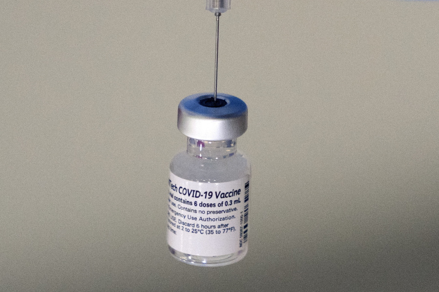 FILE - A syringe is placed into a vial of Pfizer-BioNTech vaccination at a COVID-19 clinic in Augusta, Maine, on Tuesday, Dec. 21, 2021. On Thursday, Oct. 20, 2022, Pfizer said it will charge $110 to $130 for a dose of its COVID-19 vaccine once the U.S. government stops buying the shots, but the drugmaker says it expects many people will continue receiving doses for free. (AP Photo/Robert F.