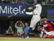 New York Yankees' Aaron Judge hits a solo home run, his 62nd of the season, during the first inning in the second baseball game of a doubleheader against the Texas Rangers in Arlington, Texas, Tuesday, Oct. 4, 2022. With the home run, Judge set the AL record for home runs in a season, passing Roger Maris.