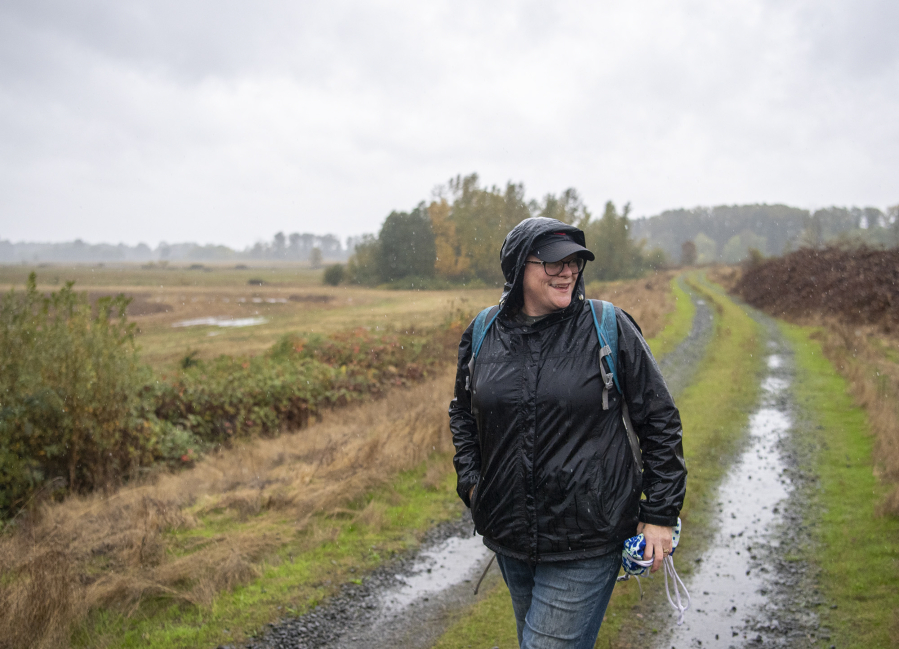 Eileen Cowen of Vancouver walks down a road at Shillapoo Wildlife Area to forage for berries, mushrooms and other goods.