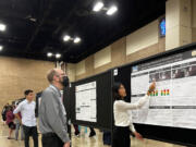 Joy Young, right, highlights a piece of her research on axonopathy to a conference attendee on Oct. 11 at the 2022 Biomedical Engineering Society Conference in San Antonio, Texas.