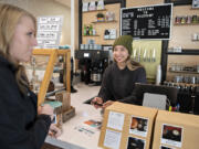Katie Atkinson of the Greater Vancouver Chamber, left, talks with barista Sasha Glazyrin as she redeems her Grow the (360) gift certificate at Relevant Coffee in Vancouver's Uptown Village.