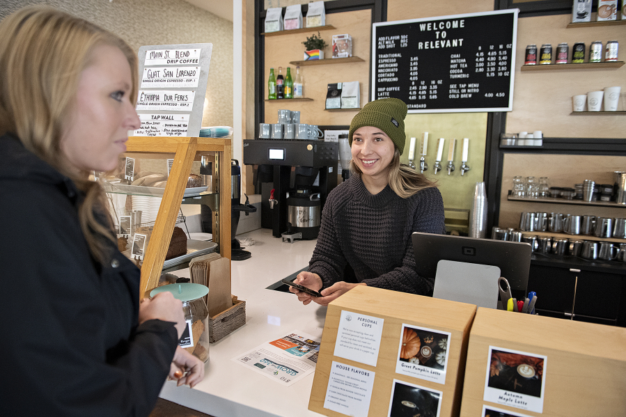 Katie Atkinson of the Greater Vancouver Chamber, left, talks with barista Sasha Glazyrin as she redeems her Grow the (360) gift certificate at Relevant Coffee in Vancouver's Uptown Village.