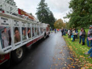Vancouver Fire Truck No. 1 displays photos of local veterans killed in action on Saturday during the Lough Legacy Veterans Parade along Evergreen Boulevard in Vancouver. At top, the Oregon Volunteer Infantry marches in the parade.