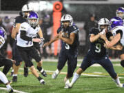 Skyview junior Trey Jacob, center, dashes through an opening Friday, Nov. 4, 2022, during the Storm’s 14-11 win against Puyallup in a 4A playoff game at Kiggins Bowl.
