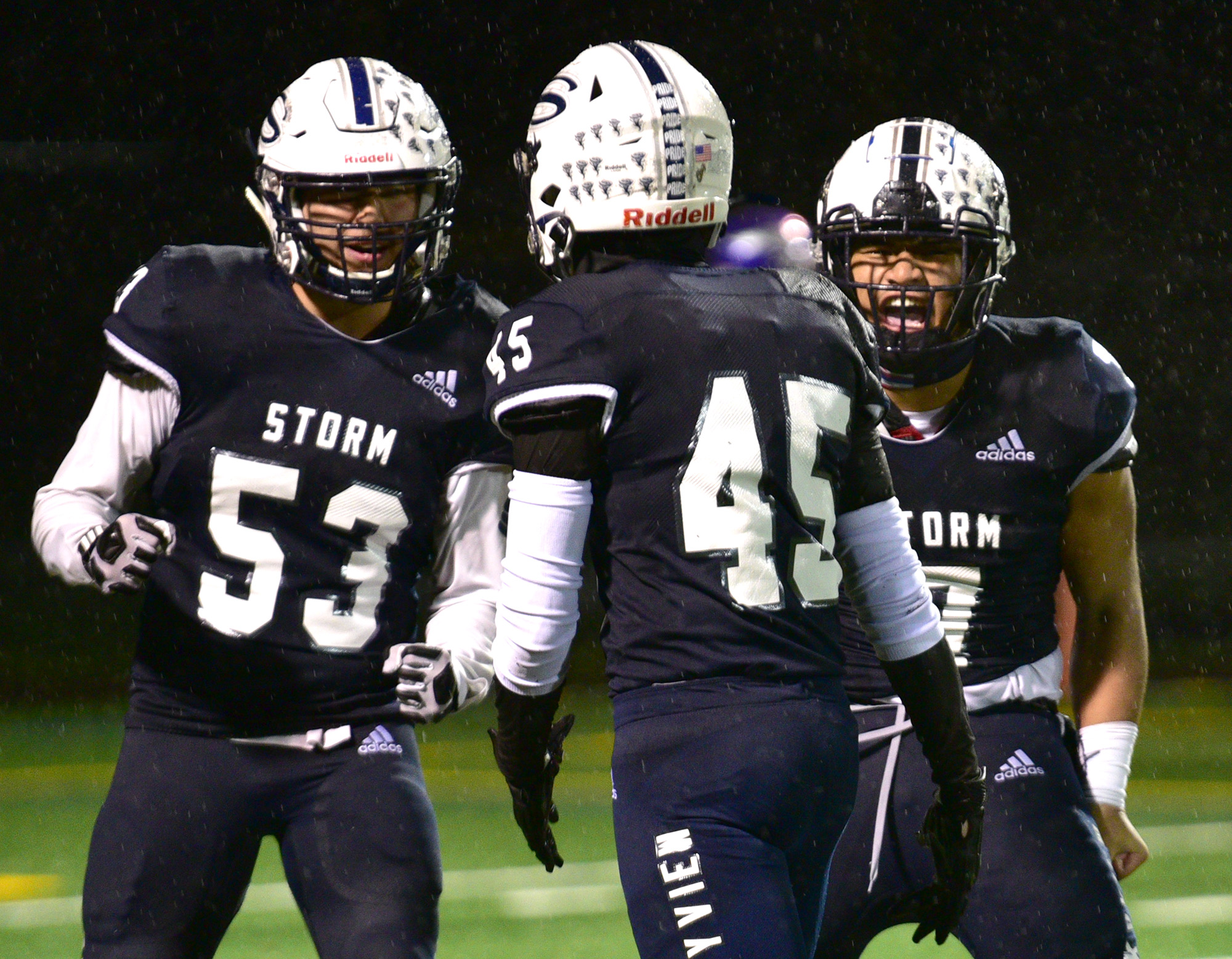 Skyview senior Alex Betancourt, left, and sophomore Hezechariah Po Ching, right, celebrate with sophomore Sam Cates after a sack Friday, Nov. 4, 2022, during the Storm’s 14-11 win against Puyallup in a 4A playoff game at Kiggins Bowl.