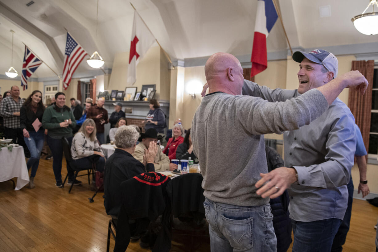Campaign manager Scott Wilcox, second from right, embraces John Horch, right, to celebrate Horch's Tuesday night lead in the Clark County sheriff's race at an election night gathering at the Red Cross Building at the Fort Vancouver National Site.