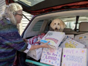 Kris Henriksen of Teen Talk joins her dog, Hope, as she takes a break with compassion boxes for students in need at her Vancouver office. The boxes are decorated on the outside by volunteers and filled with items such as snacks, pamphlets, journals and inspiring messages.