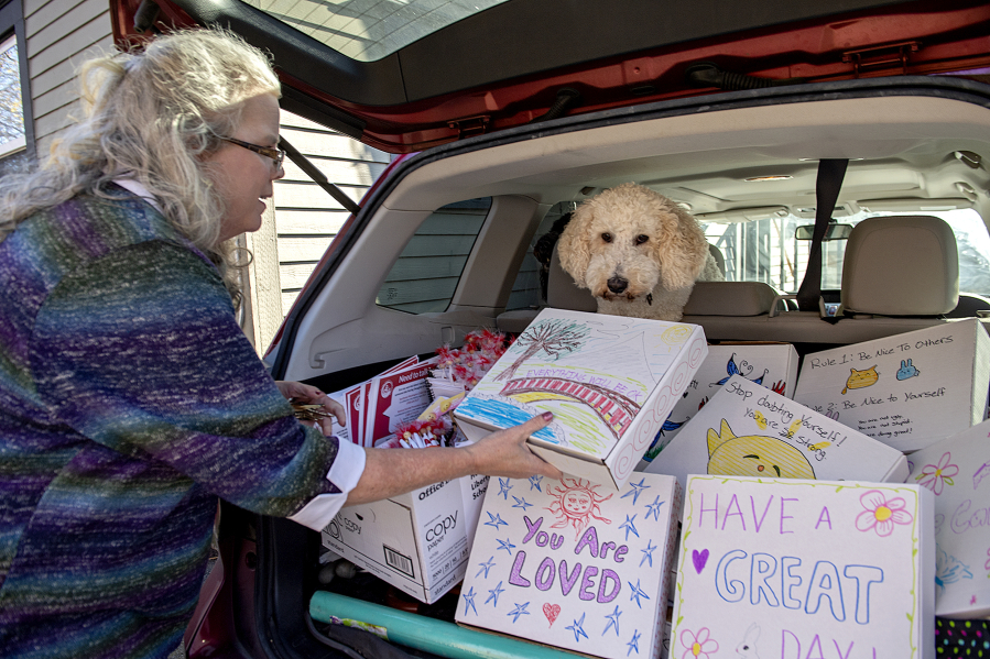Kris Henriksen of Teen Talk joins her dog, Hope, as she takes a break with compassion boxes for students in need at her Vancouver office. The boxes are decorated on the outside by volunteers and filled with items such as snacks, pamphlets, journals and inspiring messages.