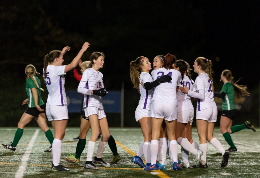 Columbia River players swarm goalscorer Avah Eslinger after a second-half brace in the 2A state soccer semifinals on Friday at Shoreline Stadium.
