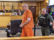 Roy Russell, center, walks out of Clark County Superior Court Judge David Gregerson's courtroom Friday, at the Clark County Courthouse. Russell's life sentence for the 2005 murder of 14-year-old Chelsea Harrison was vacated due to a change in the state's three-strikes law, and he was resentenced to 26 years in prison.