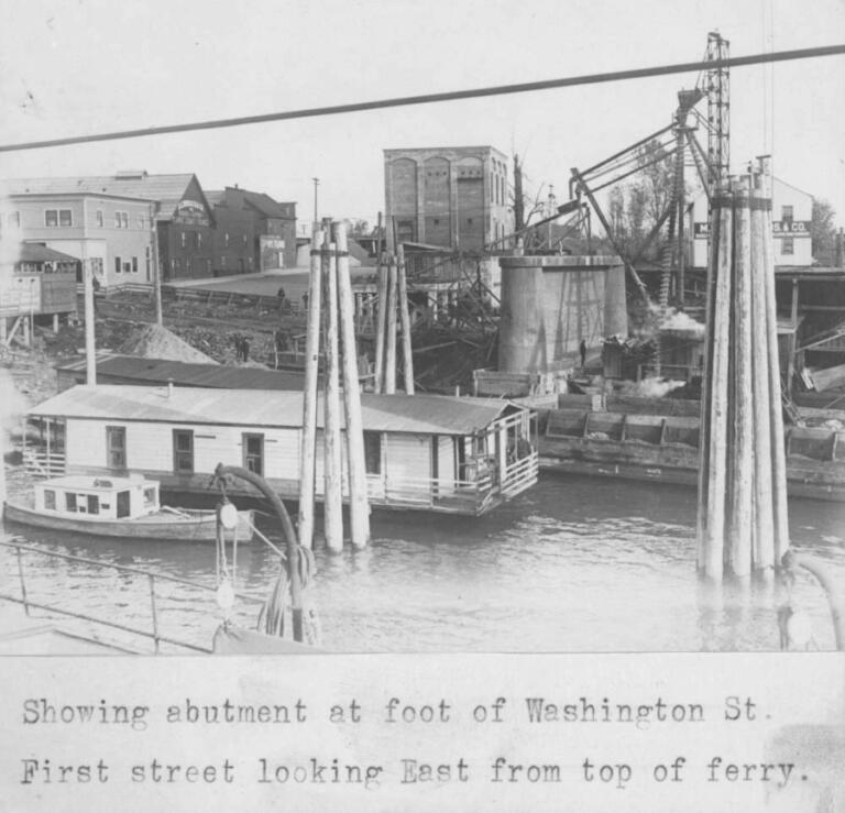 Clark County's first power substation stands in the center of this 1915 photo taken from the Vancouver ferry landing looking east. A pier for the Interstate Bridge, which was under construction, can also be seen in the photograph.