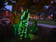 Bryon Ledin of Clark Public Utilities, left, works with colleague Spencer Fix as they test colorful holiday lights at Esther Short Park on Monday afternoon. The Rotary Community Tree Lighting will kick off at 4 p.m. Friday after a two-year hiatus from its in-person celebrations.