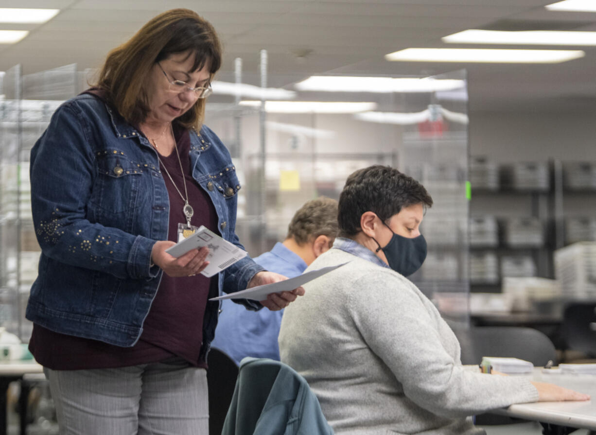 Clark County Elections Director Cathie Garber hands challenged ballots to Canvassing Board member Amanda Migchelbrink for one last review before the 2022 general election results are certified Tuesday.