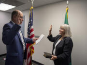 County Auditor Greg Kimsey, left, swears in new District 5 Councilor Sue Marshall at the Clark County Elections Office on Wednesday.