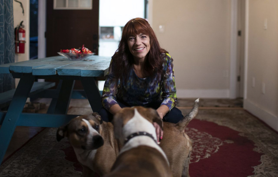 Doll Crain sits in the dining area of her Portland home with her dogs, Lady and Sue.