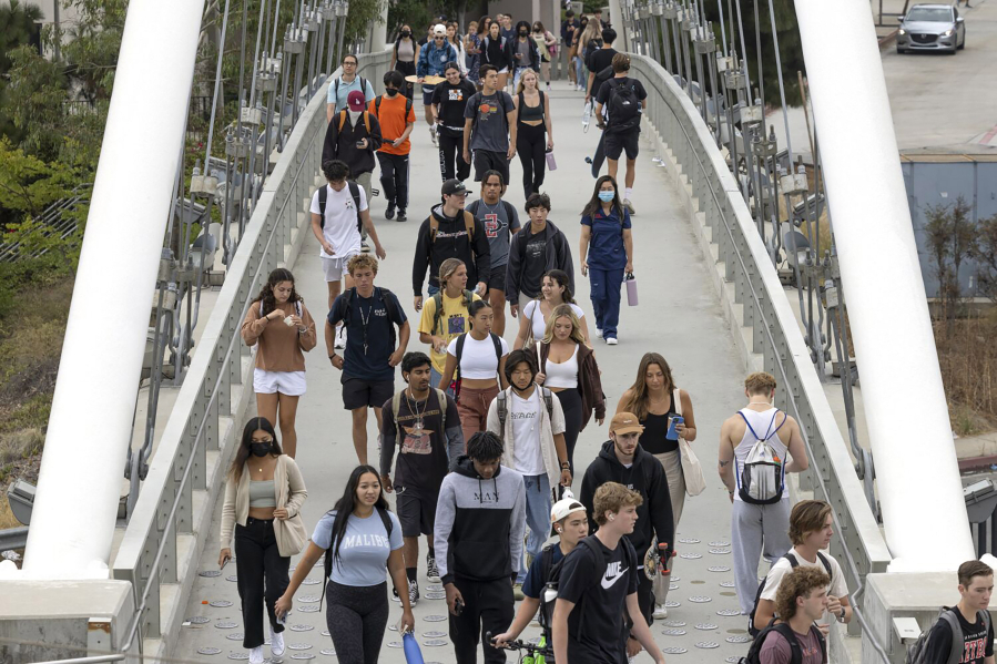 The pedestrian bridge over College Avenue is crowded with students as they head toward the SDSU campus during the official first day of fall 2022 classes at San Diego State University in San Diego on Aug. 22, 2022.