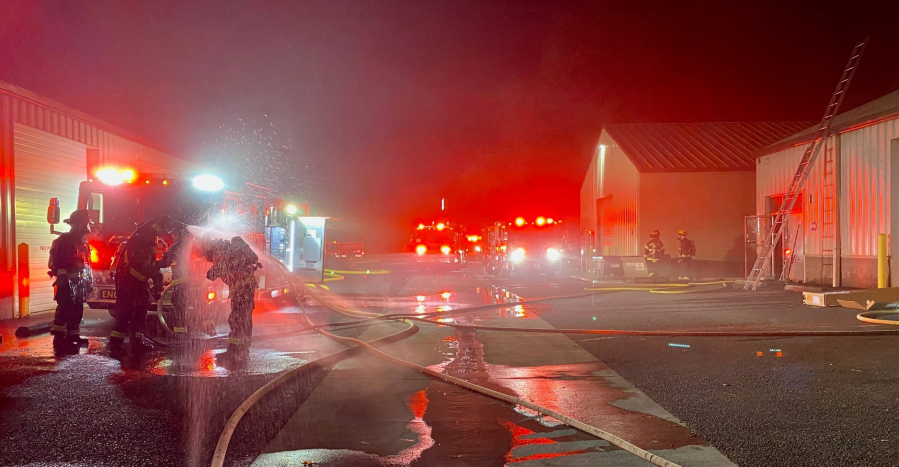 Firefighters decontaminate after extinguishing a fire Tuesday morning at an Orchards business complex. The Vancouver Fire Department upgraded the response to a second alarm and received assistance from Clark County Fire District 6 and Clark County Fire District 3.