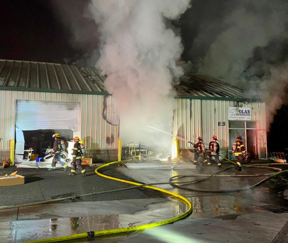 Firefighters battle a blaze Tuesday morning at an Orchards business complex. The building was unoccupied at the time, and no one was injured.