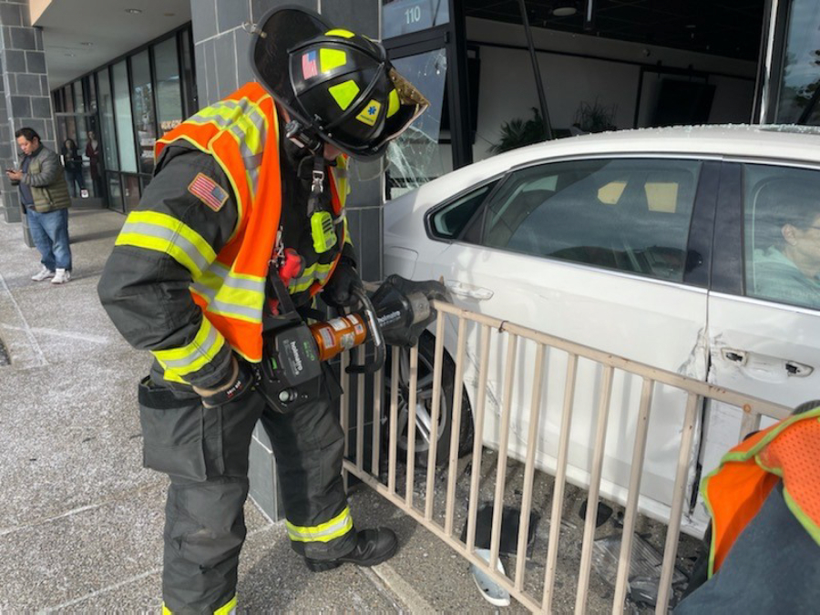 Vancouver firefighters work to extricate a driver from her car Monday morning after it crashed into a restaurant in a central Vancouver strip mall.