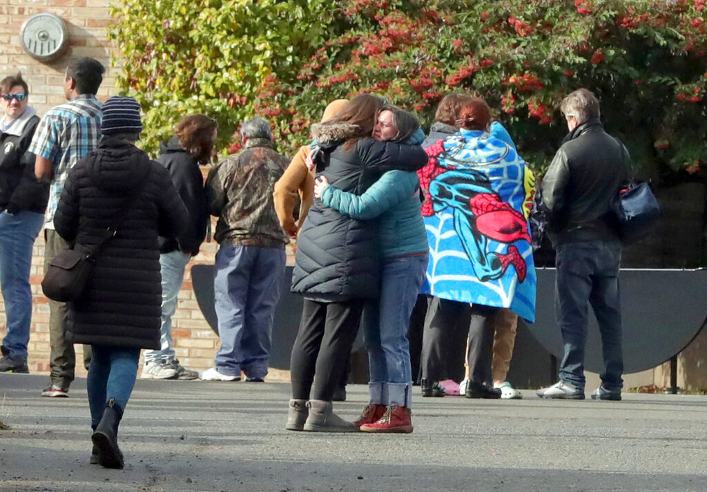Parents comfort each other outside of Ingraham High School after reports of a school shooting in Seattle, on Tuesday, Nov. 8, 2022. A student who was shot at the Seattle high school has died and a suspect is in custody, officials said.