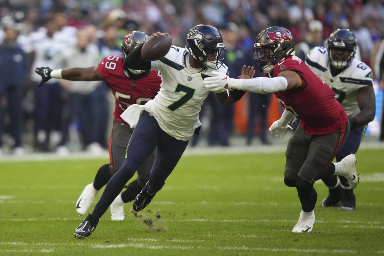 Seattle Seahawks quarterback Geno Smith (7) is sacked by Tampa Bay Buccaneers' Joe Tryon-Shoyinka (9) during the first half of an NFL football game, Sunday, Nov. 13, 2022, in Munich, Germany.