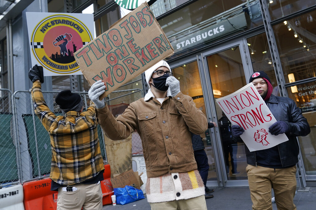People chant and hold signs in front of a Starbucks in New York, Thursday, Nov. 17, 2022. Starbucks workers at more than 100 U.S. stores say they're going on strike Thursday in what would be the largest labor action since a campaign to unionize the company's stores began late last year.