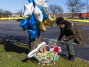 Shyleana Sausedo-Day, from Portsmouth, Va., places flowers near the scene of a mass shooting at a Walmart, Wednesday, Nov. 23, 2022, in Chesapeake, Va. A Walmart manager opened fire on fellow employees in the break room of the Virginia store, killing several people in the country’s second high-profile mass shooting in four days, police and witnesses said Wednesday.