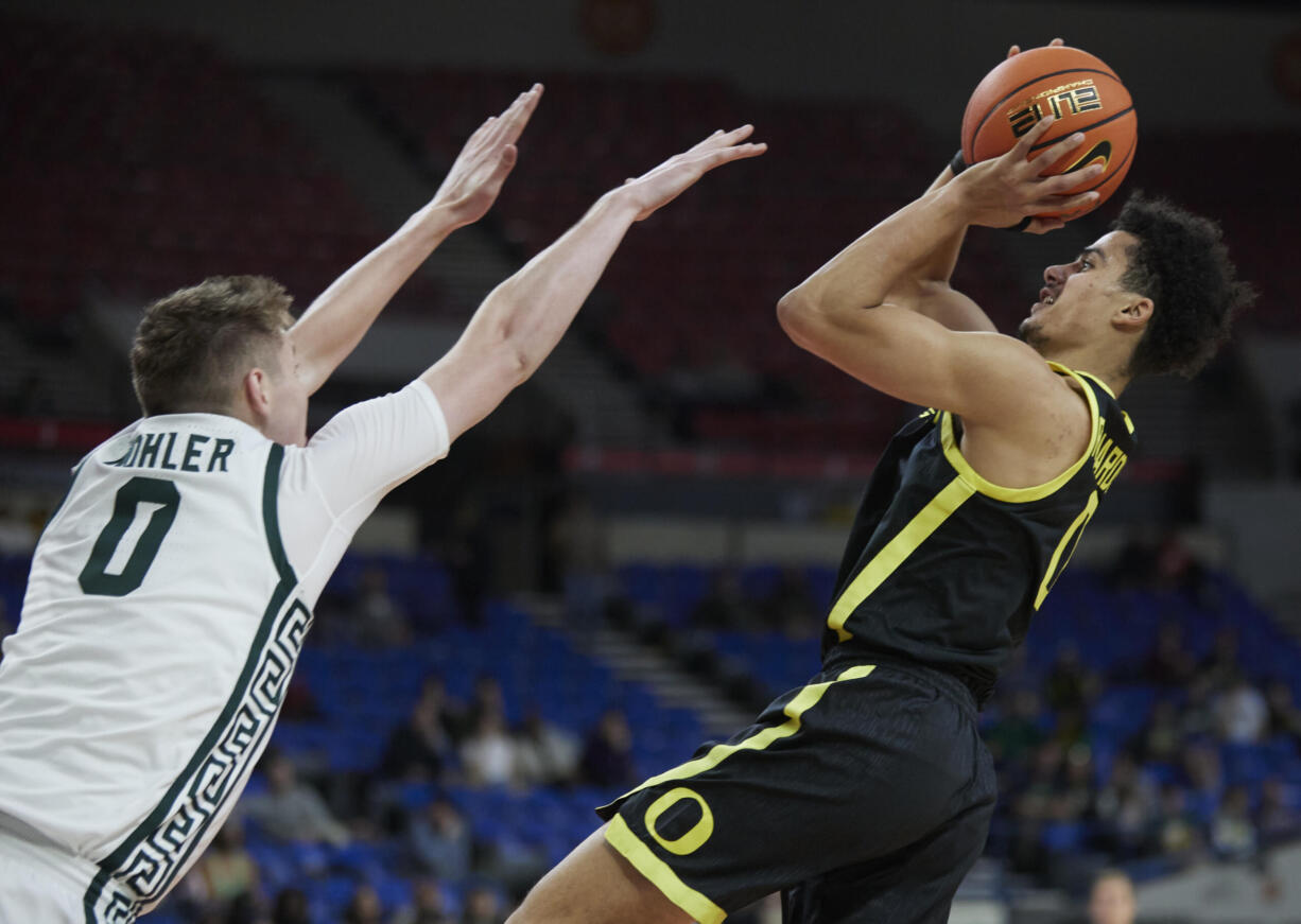 Oregon guard Will Richardson, right, shoots over Michigan State forward Jaxon Kohler during the first half of an NCAA college basketball game in the Phil Knight Invitational tournament in Portland, Ore., Friday, Nov. 25, 2022.