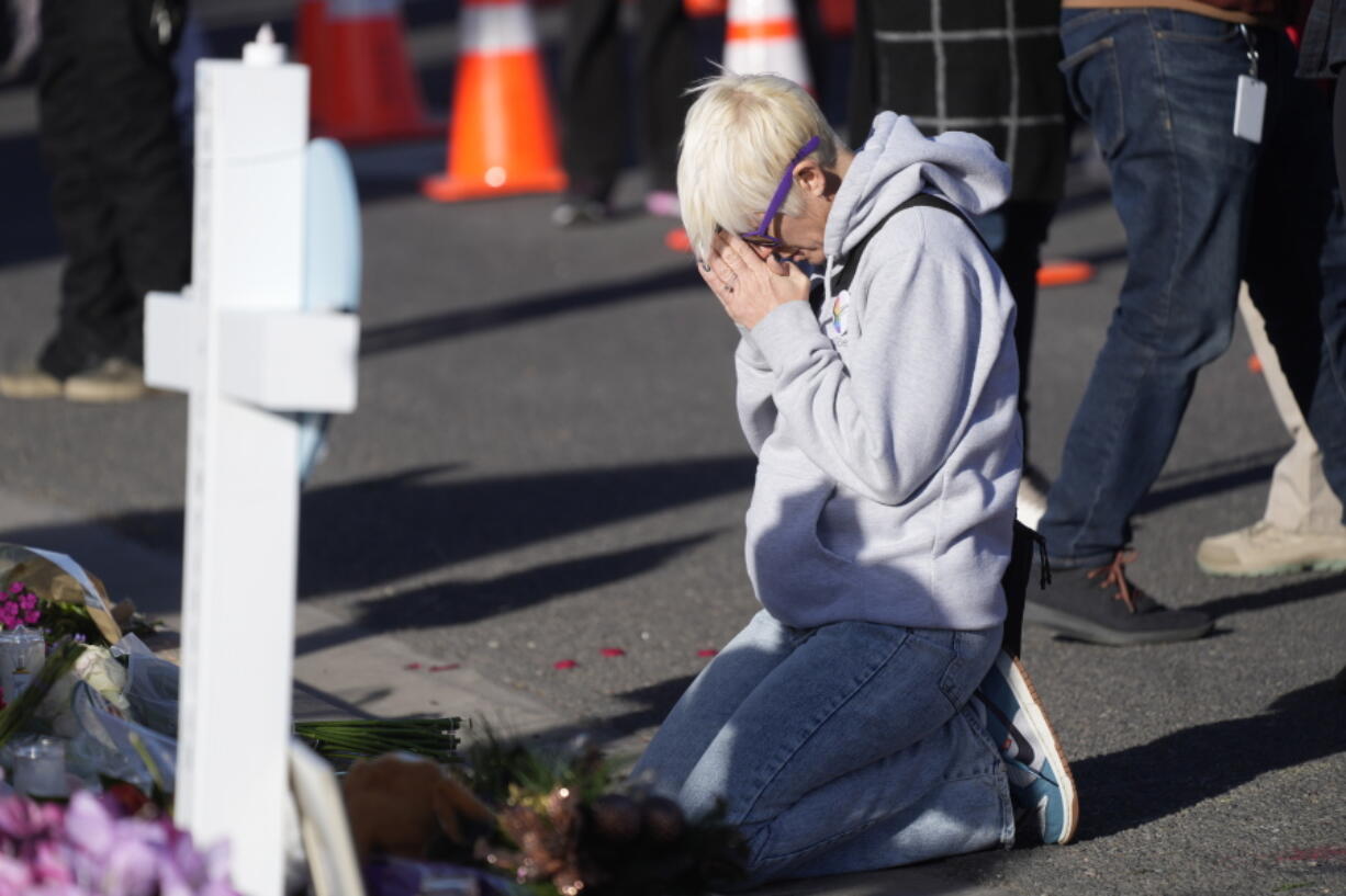 Dallas Dutka of Broomfield, Colo., prays by a makeshift memorial, Tuesday Nov. 22, 2022, for the victims of a mass shooting at a gay nightclub in Colorado Springs, Colo. Dutka's cousin, Daniel Aston, was killed in the shooting.