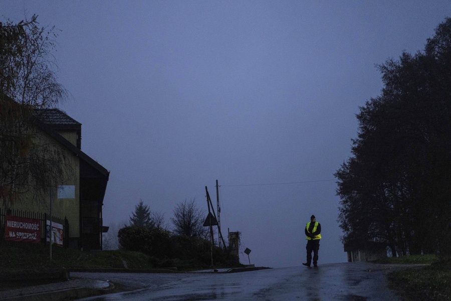 A police officer stands at a checkpoint near the scene of a blast in Przewodow, Poland, Wednesday, Nov. 16, 2022. Poland said Wednesday that a Russian-made missile fell in the country's east, though U.S. President Joe Biden said it was "unlikely" it was fired from Russia.