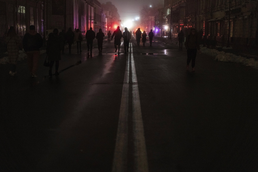 People walk at the city center which lost electrical power after yesterday's Russian rocket attack in Kyiv, Ukraine, Thursday, Nov. 24, 2022.