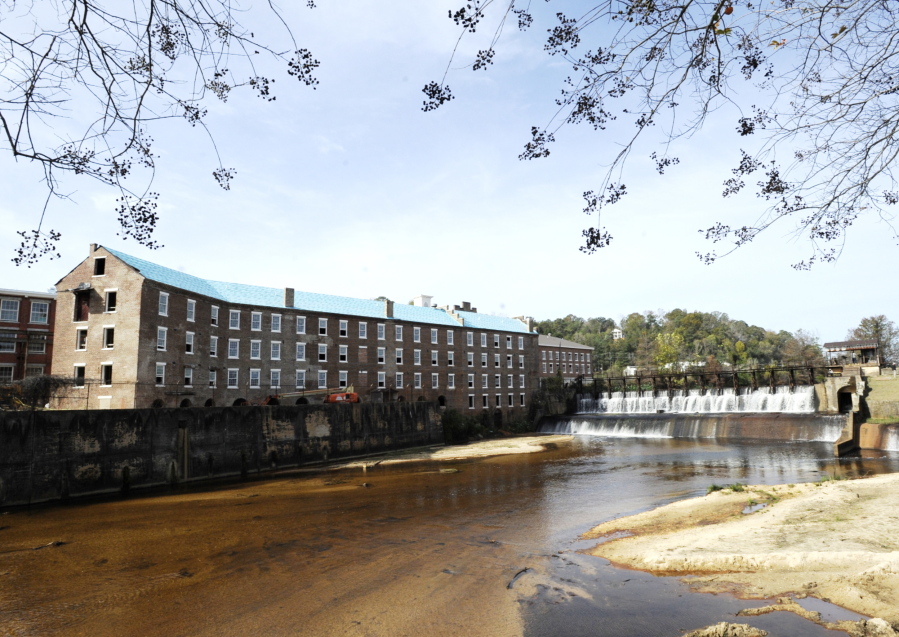 A once-abandoned cotton gin factory that is being renovated into apartments stands beside Autauga Creek in Prattville, Ala., on Thursday, Nov. 10, 2022. The factory's history is tied up in slavery, and the project demonstrates the difficulty of telling complicated U.S. history.