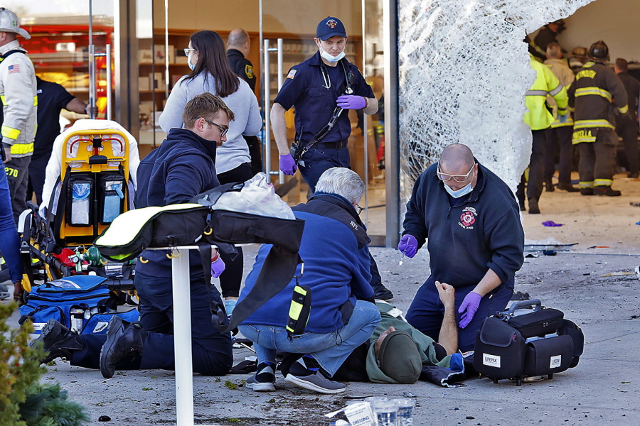 Emergency workers aid injured shoppers after an SUV drove into an Apple store, Monday, Nov. 21, 2022, in Hingham, Mass. Several people were injured in the incident, according to authorities.