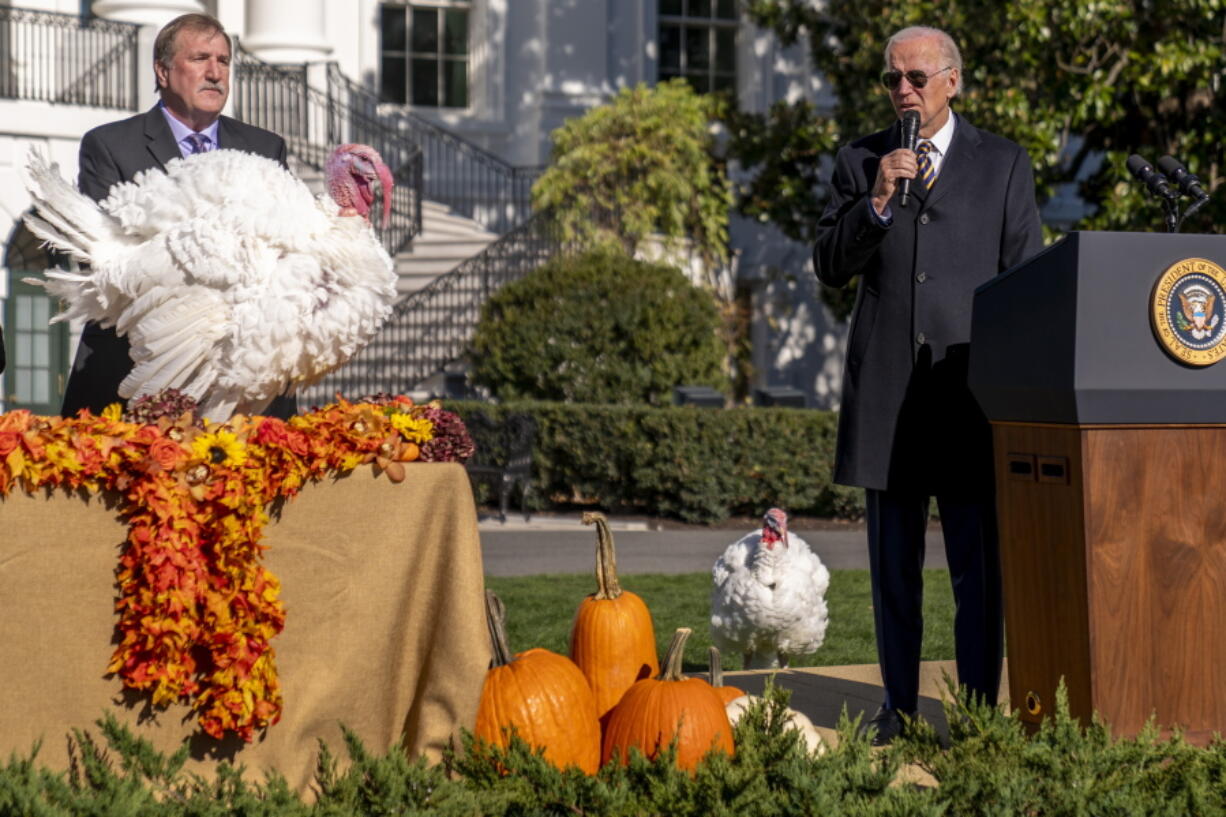 President Joe Biden, accompanied by Ronald Parker, Chairman of the National Turkey Federation, left, speaks next to Chocolate, the national Thanksgiving turkey, left, during a pardoning ceremony at the White House in Washington, Monday, Nov. 21, 2022. Chip, the national Thanksgiving turkey, is at bottom right.