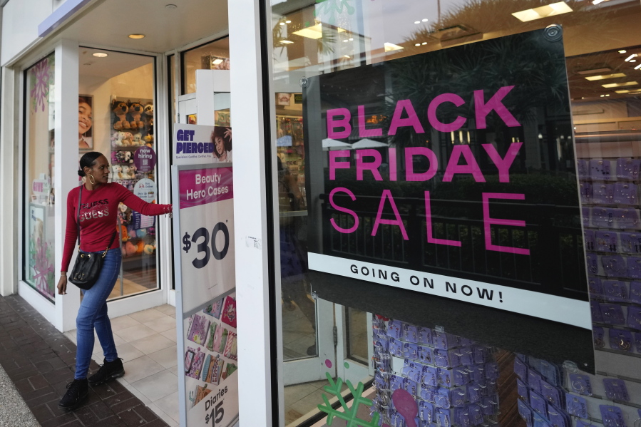 Shoppers exit a Claire's accessories store advertising sales ahead of Black Friday and the Thanksgiving holiday, Monday, Nov. 21, 2022, in Miami. Retailers are ushering in the start of the holiday shopping season on the day after Thanksgiving, preparing for the biggest crowds since 2019.