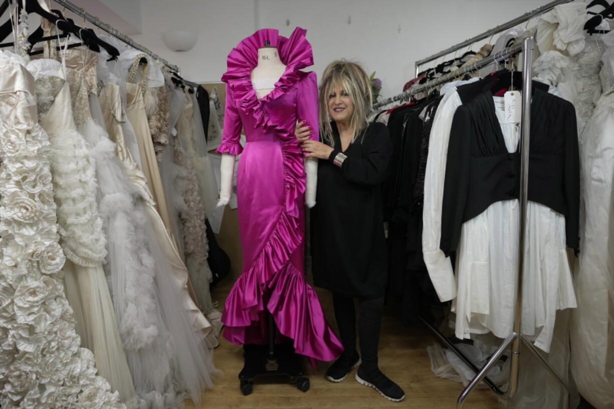 British designer Elizabeth Emanuel stands beside a replica of an evening gown she designed for the then Lady Diana Spencer to wear at a Buckingham Palace party a few days before her marriage to Prince Charles in 1981, in London, Friday, Nov. 18, 2022. Emanuel recreated the dress for her own archive and to show another side of Diana, who Emanuel believes has been misrepresented by "The Crown," the popular Netflix series that has brought the story of the princess and her ill-fated marriage to a new generation.