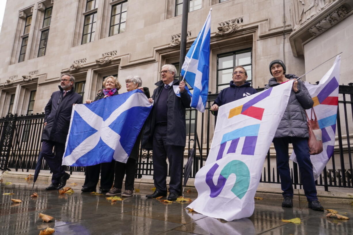 Scottish flags are held by demonstrators, outside the Supreme Court, in London, Wednesday, Nov. 23, 2022. The U.K. Supreme Court ruled Wednesday that Scotland does not have the power to hold a new referendum on independence without the consent of the British government.