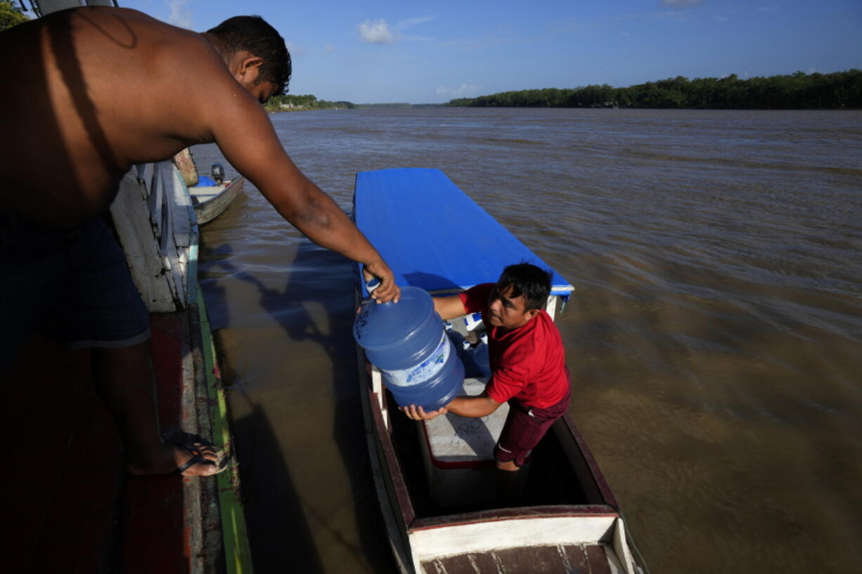 Gallons of water for human consumption are transported on passenger boats to serve communities located on the islands of the Bailique Archipelago in the district of Macapa, state of Amapa, northern Brazil, Saturday, Sept. 10, 2022. The Amazon River discharges one-fifth of all the world's freshwater that runs off land surface. Despite that force, the seawater pushed back the river that bathes the archipelago for most of the second half of 2021, leaving thousands scrambling for drinking water.