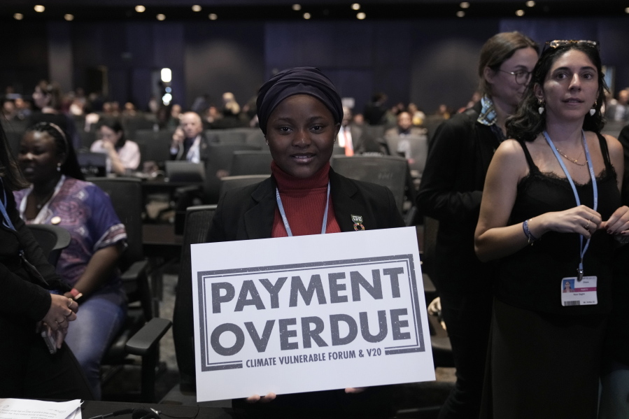 Nakeeyat Dramani Sam, of Ghana, holds a sign that reads "payment overdue" at the COP27 U.N. Climate Summit, Friday, Nov. 18, 2022, in Sharm el-Sheikh, Egypt. She made a plea for negotiators at the summit to come to an agreement that could help curb global warming.