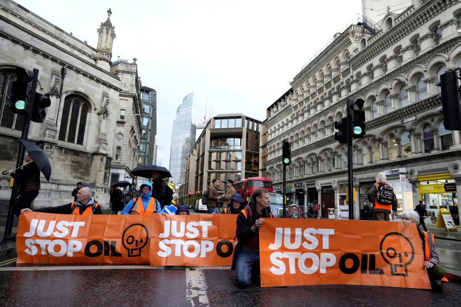 FILE - Activists from the group Just Stop Oil block a road in London, Thursday, Oct. 27, 2022 demanding to stop future gas and oil projects from going ahead. British climate activists who have blocked roads and splattered artworks with soup said Friday, Nov. 11, 2022, that they are suspending a days-long protest that has clogged a major highway around London.