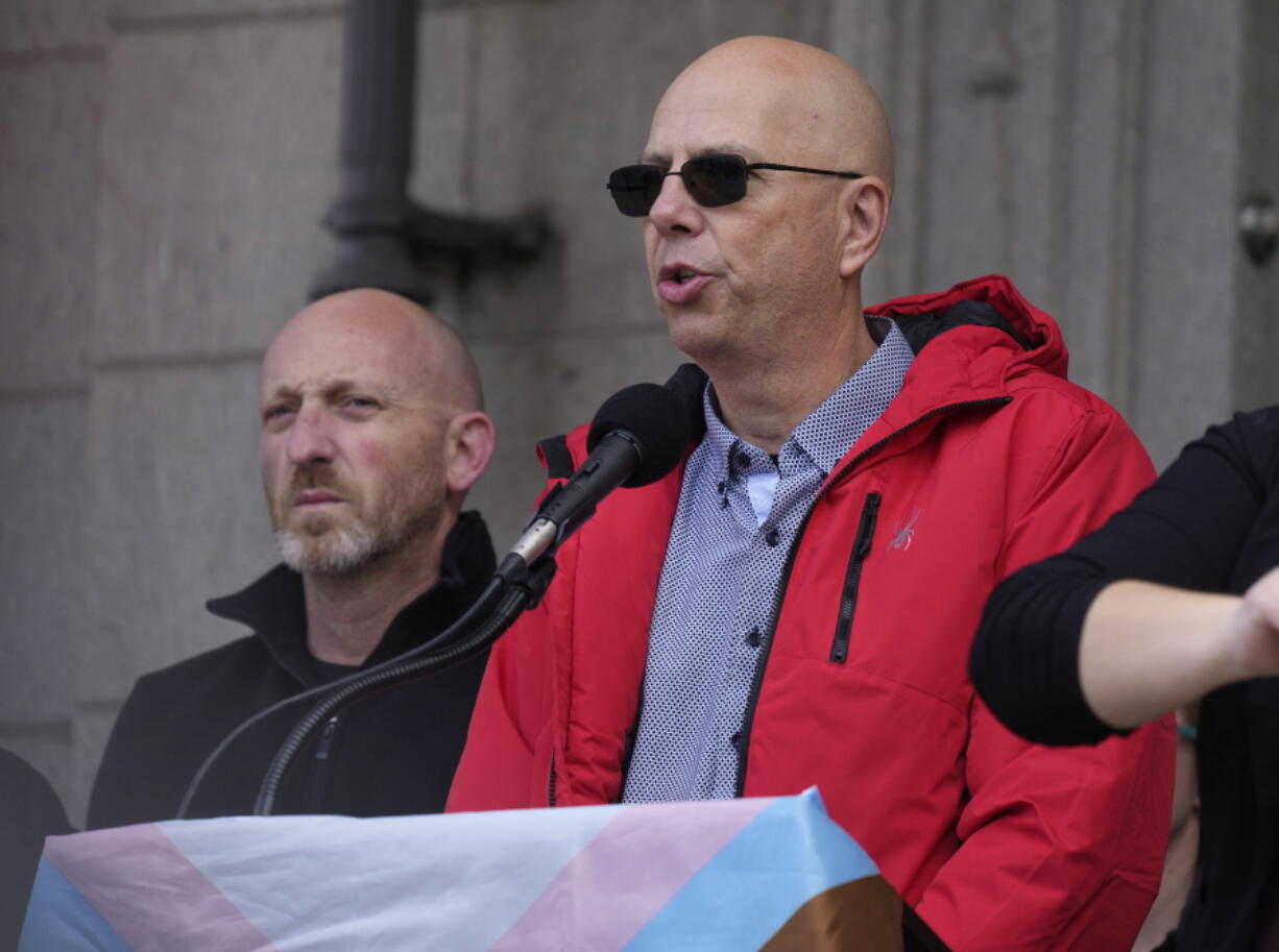 Co-owners of Club Q, Matthew Haynes, front, and Nic Grzecka, address the crowd after a 25-foot historic pride flag was displayed on the exterior of City Hall to mark the weekend mass shooting at the gay nightclub Wednesday, Nov. 23, 2022, in Colorado Springs, Colo. The flag, known as Section 93 of the Sea to Sea Flag, is on loan for two weeks to Colorado Springs from the Sacred Cloth Project.